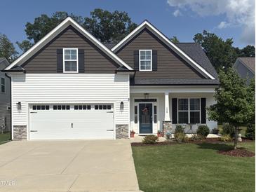 Charming home featuring white siding, stone accents, a two-car garage, and a well-manicured lawn at 108 Sweetbay Park, Youngsville, NC 27596