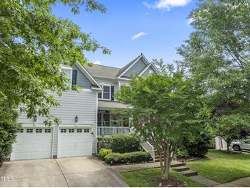 Charming two-story home with a well-manicured lawn, two-car garage, and inviting front porch at 10859 Bedfordtown Dr, Raleigh, NC 27614