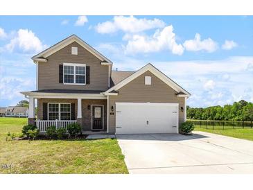 Inviting two-story home featuring a covered porch, attached garage, and well-maintained lawn in a desirable neighborhood at 167 Young Farm Dr, Lillington, NC 27546