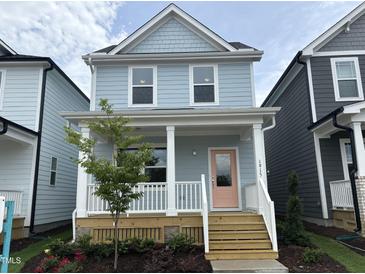 Charming two-story home with a welcoming porch and a pink front door at 1915 Plott Balsam Dr, Wendell, NC 27591