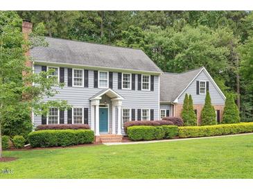 Charming two-story home with blue siding, black shutters, and manicured landscaping at 2008 Corberrie Ln, Raleigh, NC 27613