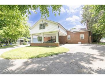 Brick home featuring a covered carport, concrete driveway, and well-maintained lawn at 219 E Nash St, Spring Hope, NC 27882