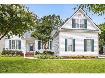 Charming white home with green shutters, a manicured lawn, and mature trees at 2311 Woodwyck Way, Raleigh, NC 27604