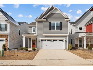 Charming two-story home with gray siding, white trim, two-car garage and a vibrant red front door at 2346 Mckenzie Ridge Ln, Apex, NC 27502
