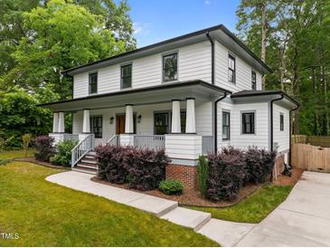 Charming two-story home featuring a welcoming front porch, manicured lawn, and beautiful landscaping at 2551 Drake Ave, Durham, NC 27705