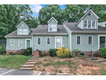Inviting exterior of a townhouse with a manicured lawn and appealing architectural details and concrete steps and white rails at 410 Oak Run Dr, Raleigh, NC 27606