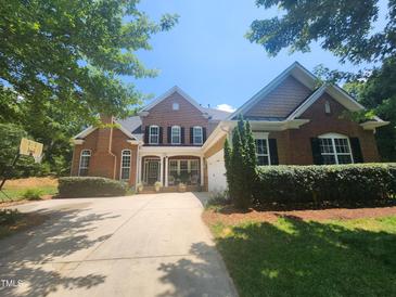 Charming brick home featuring a well-manicured lawn, symmetrical design, and inviting front porch at 502 Willowmere Ct, Cary, NC 27513