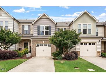 Charming townhome with attached garages, manicured lawn, and inviting curb appeal at 107 Tuftin Dr, Durham, NC 27703