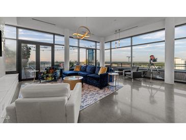 Bright, modern living room features floor-to-ceiling windows, stylish furnishings, and a spacious open layout at 122 N Harrington St # 1555, Raleigh, NC 27603