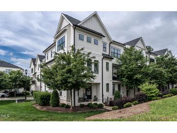 Beautiful white townhome featuring black trim, multiple windows and professionally landscaped yard at 1610 Draper View Loop # 101, Raleigh, NC 27608