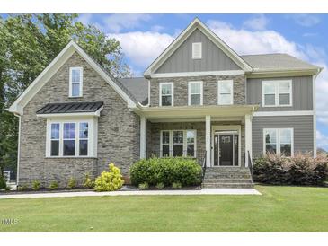 Charming two-story home with stone and gray siding, manicured lawn, and inviting front porch at 1625 Banks View Dr, Raleigh, NC 27603