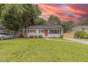 Charming single-story home featuring a well-maintained lawn and an inviting orange front door at 1708 Forest Rd, Durham, NC 27705