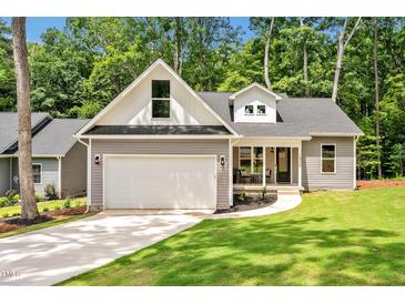 Charming home featuring a two-car garage, lush lawn, and appealing architectural details at 1824 Irish Blvd, Sanford, NC 27332