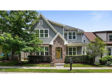 Charming two-story home features a manicured lawn, brick accents, and a welcoming yellow front door at 1962 Briar Chapel Pkwy, Chapel Hill, NC 27516