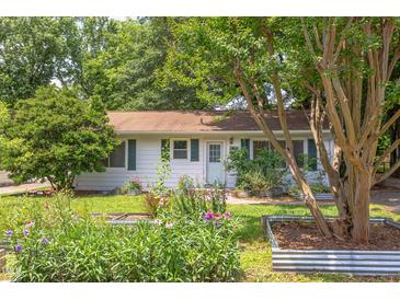 Charming single-story home featuring a well-manicured lawn, inviting entrance, and landscaped garden beds at 2009 Carolina Ave, Durham, NC 27705