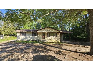 Quaint single-story home nestled among trees, with siding and charming shutters at 2100 N Webb St, Selma, NC 27576
