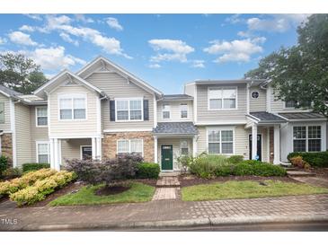 Charming townhome featuring manicured landscaping and inviting green front door under a cloudy blue sky at 3519 Sugar Tree Pl, Durham, NC 27713