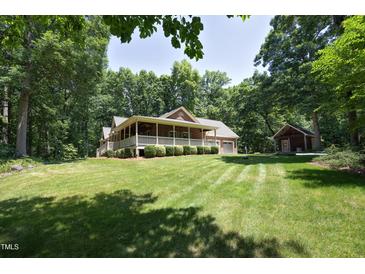 Beautiful brick home featuring a large lawn, covered porch and mature trees at 5464 Bass Mountain Rd, Snow Camp, NC 27349