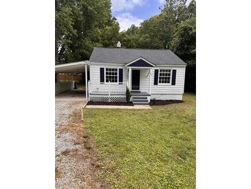 Charming home featuring a quaint front porch, white siding, and a convenient carport at 603 S Third St, Mebane, NC 27302