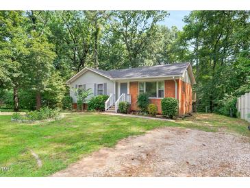 Charming brick and siding home with a well-maintained front yard and a gravel driveway at 106 Lattimore Ln, Durham, NC 27713