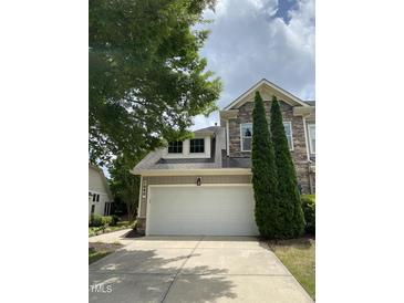 Two-story home featuring a two-car garage, stone accents, and manicured landscaping at 1090 Indigo Ridge Pl, Cary, NC 27519