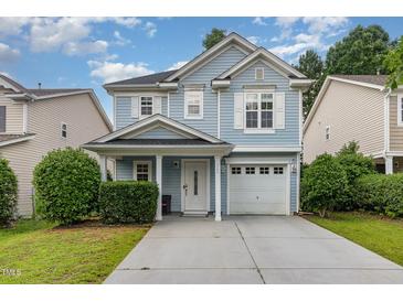Charming two-story home with light blue siding, white trim, and a well-maintained front yard at 128 Palmdale Ct, Holly Springs, NC 27540