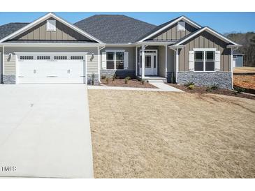Charming single-Gathering home featuring stone accents, a two-car garage, and a well-manicured lawn at 148 Merrifield Ln # 128, Garner, NC 27529