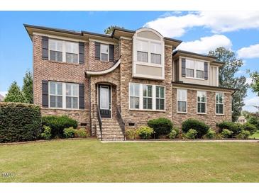 Inviting two-story home with brick and stone facade, manicured lawn, and lovely landscaping at 150 Saint Mellion St, Raleigh, NC 27603