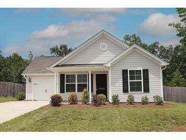 Charming single-story home featuring a landscaped front yard and attached garage, showcasing modern curb appeal at 1848 Glenn St, Burlington, NC 27217