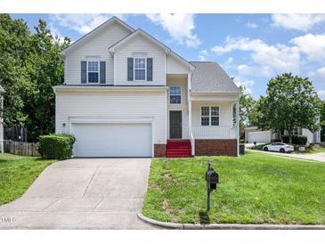 Charming two-story home with a manicured lawn, attached garage, and inviting front porch at 2241 Spruce Shadows Ln, Raleigh, NC 27614