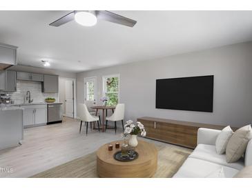 Open-concept living room featuring modern decor, ample seating, and seamless flow into kitchen at 2702 Red Valley Dr, Rougemont, NC 27572