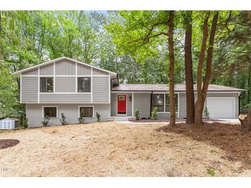 Charming split-level home with gray siding, brick accents, and a vibrant red front door at 2905 Scuppernong Ln, Durham, NC 27703