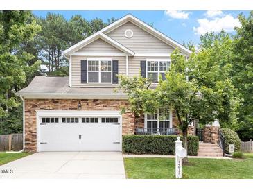 Charming two-story home features a stone facade, well-manicured lawn, and a two-car garage at 3217 Ranbir Dr, Durham, NC 27713