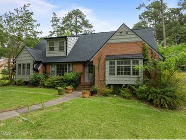 Charming brick home with mature landscaping and a well-maintained lawn on a sunny day at 3516 Swift Dr, Raleigh, NC 27606