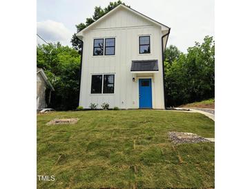 Charming two-story home features a bright blue front door, black trimmed windows, and well-manicured lawn at 608 A E Umstead, Durham, NC 27701