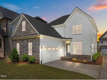 Two story home boasts stone accents, attached garage, and manicured lawn at 132 Cotten Dr, Morrisville, NC 27560