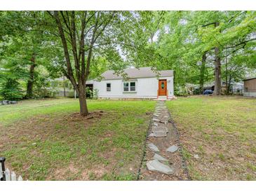 Charming single-story home featuring a stone pathway and lush greenery at 1401 Robinhood Rd, Durham, NC 27701