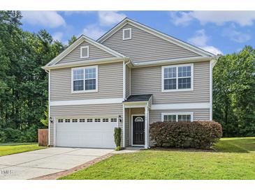 Charming two-story home showcasing neutral siding, a two-car garage, and well-manicured lawn at 160 Chandler Springs Dr, Holly Springs, NC 27540