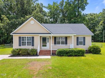 Charming single-story home with a well-manicured lawn, complemented by mature trees and an inviting front porch at 161 Bridgewater Dr, Erwin, NC 28339