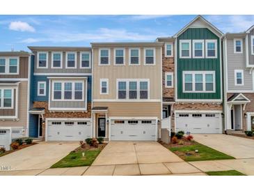 Charming townhomes showcase a mix of neutral siding and stone accents, creating an inviting street view at 2735 Hunter Woods Dr # 571, Apex, NC 27502