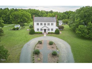 A stunning colonial style home with a sprawling front yard, and a circular driveway at 3679 Oak Lawn Farm Rd, Oxford, NC 27565