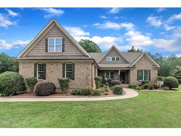 Charming brick home featuring a beautifully landscaped front yard and a mix of brick and shingle exterior at 3728 Marwick Ct, Wendell, NC 27591