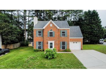 Charming two-story brick home with teal shutters and a well-manicured lawn at 5200 Fieldwood Ct, Raleigh, NC 27616