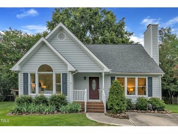 Charming single-story home with tidy landscaping, blue siding and a brick walkway leading to the front door at 8 Great Oak Ct, Durham, NC 27713