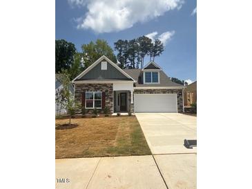 Charming home with a brick and siding exterior, a two-car garage, and manicured lawn at 85 Bald Cypress Ln, Youngsville, NC 27596