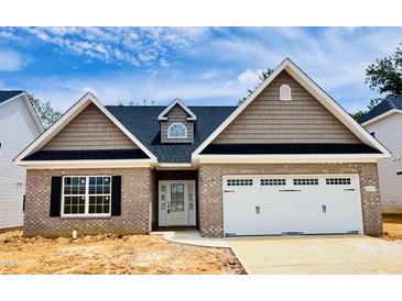 New brick home with a two-car garage, shingle and stone accents, and a well-manicured lawn at 1079 Fairhaven Dr # 50, Mebane, NC 27302