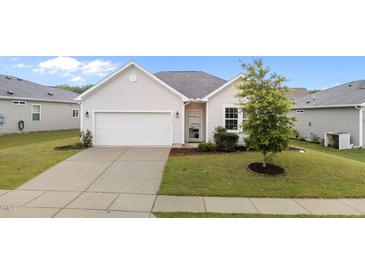 Charming one-story home featuring a well-maintained lawn, concrete driveway, and attached garage at 119 Yadkin St, Clayton, NC 27520