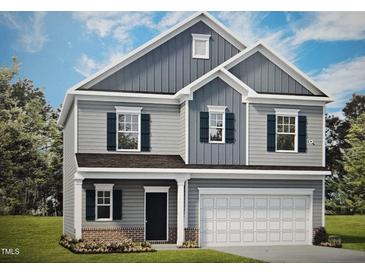 Charming two-story home featuring a welcoming front porch, attached two-car garage, and blue shutters at 158 Mildred Pl, Broadway, NC 27505