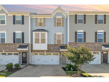 Charming townhome showcasing a brick and siding facade, inviting entrance, and an attached one-car garage at 248 Amber Acorn Ave, Raleigh, NC 27603
