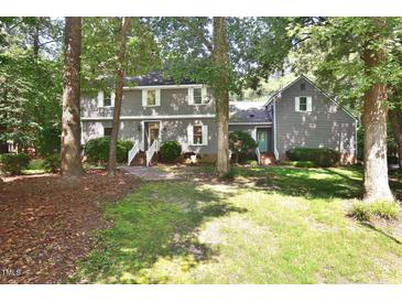 Two-story home with gray siding, white shutters, brick walkway, and well-maintained landscaping in a wooded area at 2708 Coleberry Trl, Rocky Mount, NC 27804